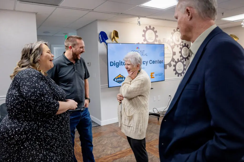 Sandra Ring, middle right, Comcast representative Kyle Weaver, middle left, and Melissa Clark, left, of Eagle Mountain Chamber of Commerce, talk before a soft launch ribbon cutting of the Digital Literacy Center at the Eagle Mountain Chamber of Commerce on Thurs., April 25, 2024 in Eagle Mountain, Utah.